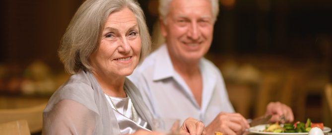 Happy mature couple eating dinner at restaurant meal plans at a CCRC