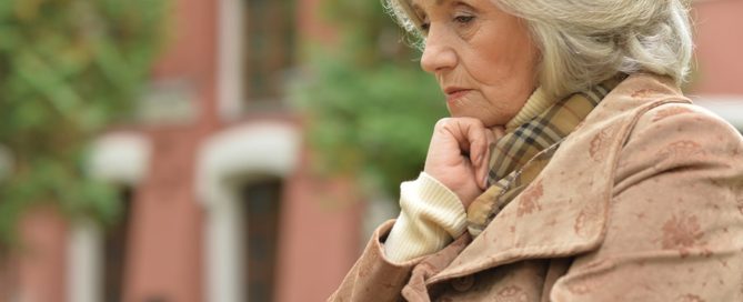 Portrait of a sad older woman in autumn park aging alone
