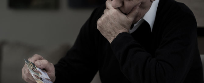 Senior sad man with photo missing his wife