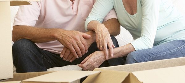 Senior Couple Moving Home And Packing Boxes