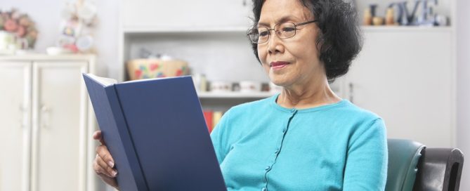 Senior Asian woman reading book at home