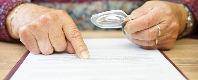 aged woman reading document with magnifying glass