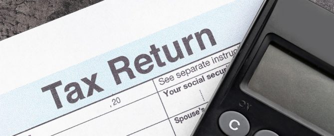 Tax return form and calculator on table