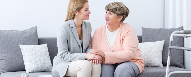 dementia communication older woman sitting on a sofa with a younger woman