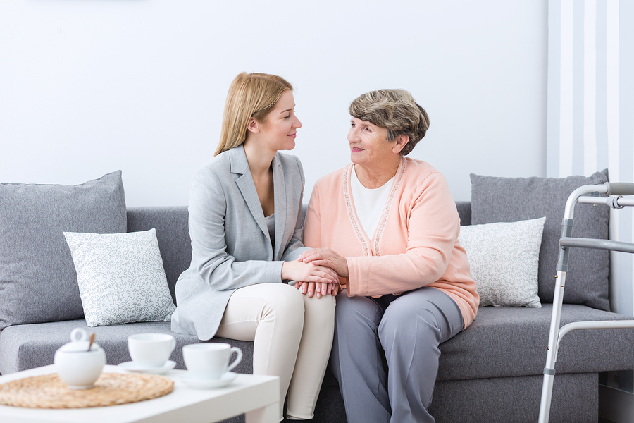dementia communication older woman sitting on a sofa with a younger woman