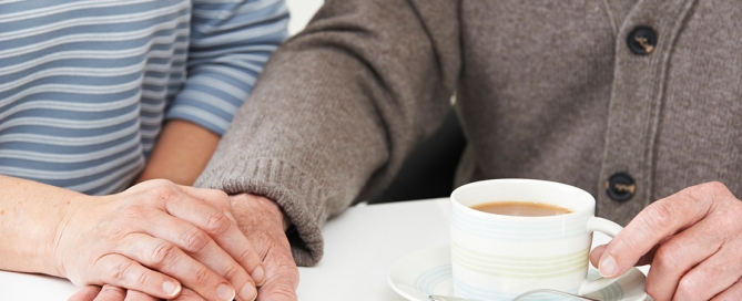 Woman Sharing Cup Of Tea With Elderly Parent