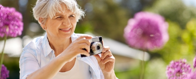woman with camera photographing flowers