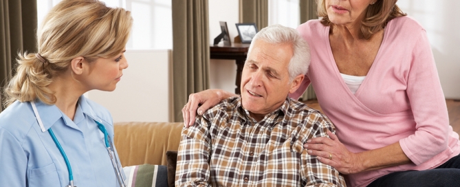 Senior Couple Talking To Health Visitor At Home