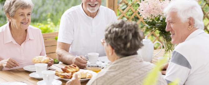 senior people having fun while eating outside with friends
