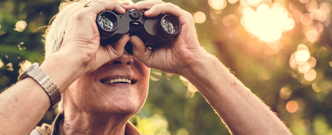 Future of CCRCs Mature man watching birds through binoculars