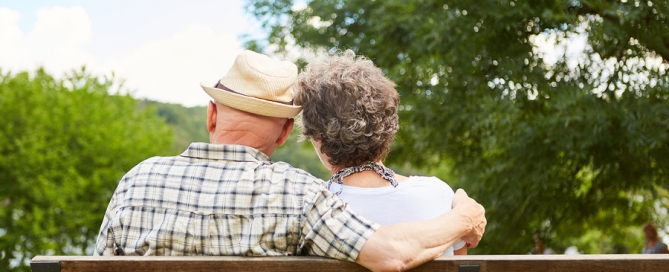 retirement location Senior couple sitting side by side on a park bench