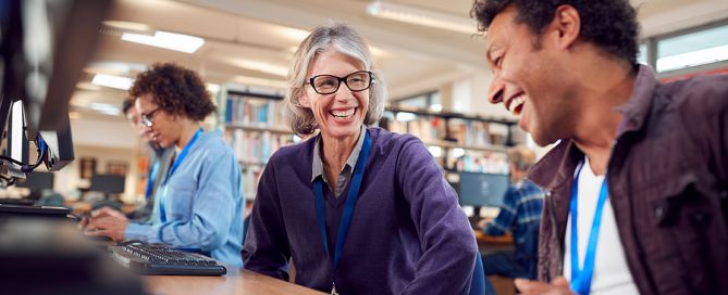 CCRCs universities partnerships Senior With Group Of college Students In Class Working At computer