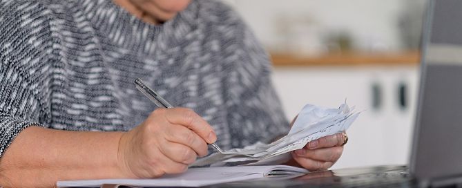 planning financially for CCRC move; woman with papers and calculator