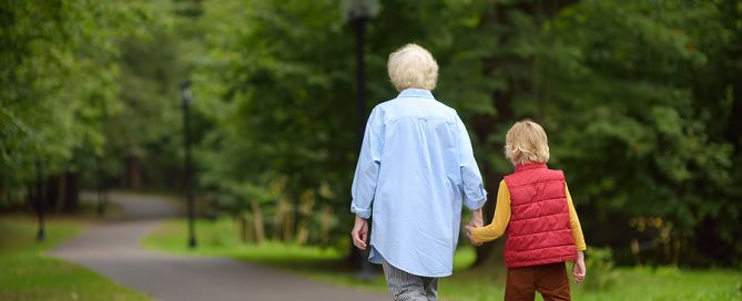 Elderly Grandmother And Her Little Grandchild Walking Together; CCRC move legacy