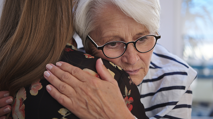 Young Woman Embracing An Elderly Lady; care for aging loved one