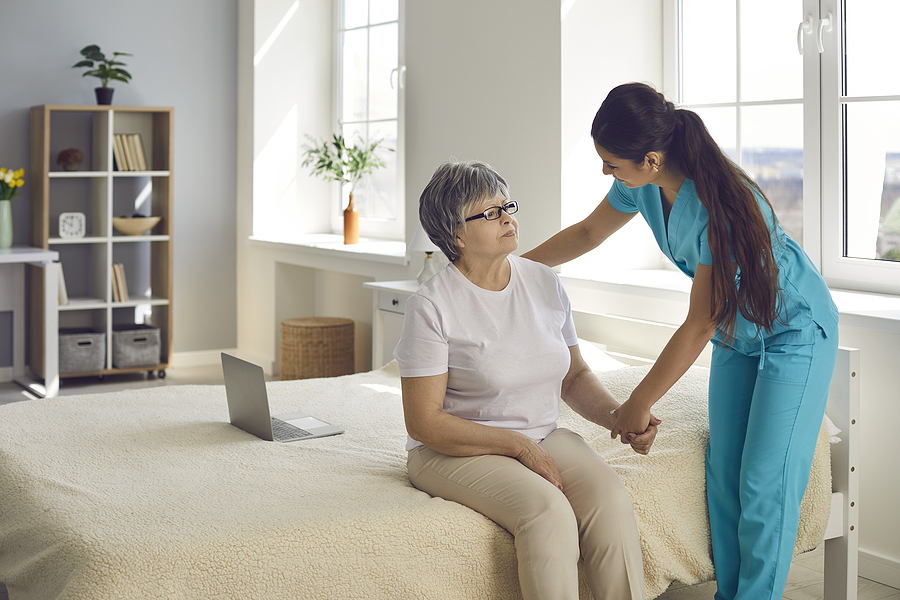 LTC staffing shortage; nurse helping older woman