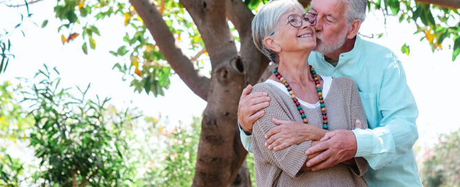 senior couple in the shade of the trees enjoying their free time and retirement - senior dating relationships