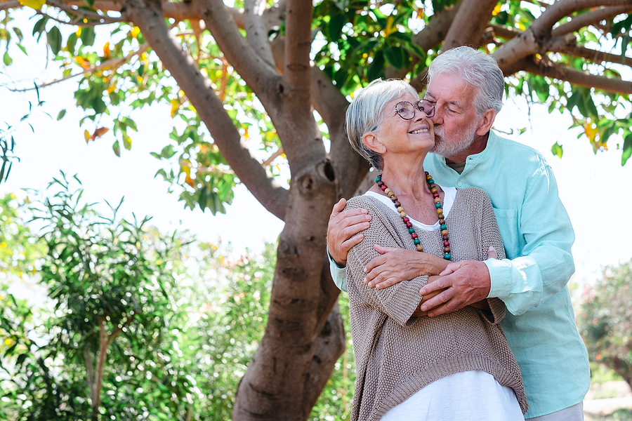 senior couple in the shade of the trees enjoying their free time and retirement - senior dating relationships