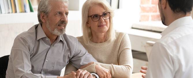 mature couple meeting with financial advisor in office
