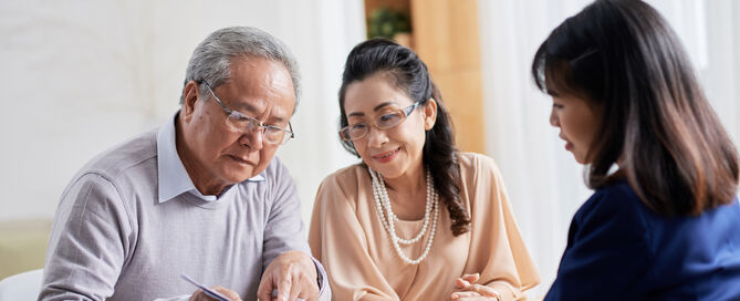 senior couple sitting at spacious office with advisor CCRC Fee Tax Deductions