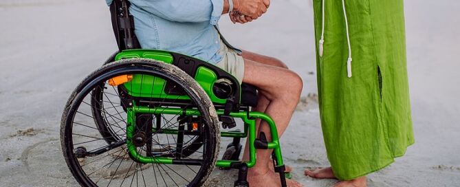 Senior Man On Wheelchair Enjoying Together Time With His Wife At Sea, Low Section. life-affirming retirement care