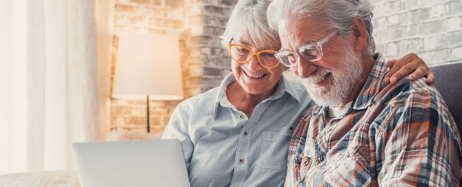 people sitting on the sofa using laptop together 55 plus community waiting list wait