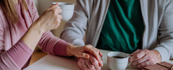 Adult Daughter Visiting Her Senior Father Having coffee senior living plan 55-plus community