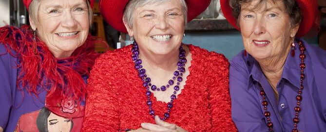 Three older Women Wearing Red Hats Social Connection Benefits of Retirement Communities