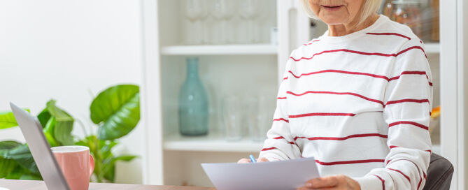 Serious older Lady Sitting At The Laptop retirement community move