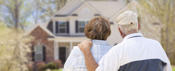 Senior Couple From Behind Looking at Front of Home that is too big