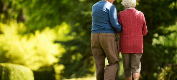 older adult couple avoiding a sedentary lifestyle by walking