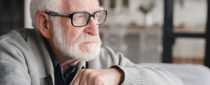 Lonely older man looking out the window; the last move to a retirement community