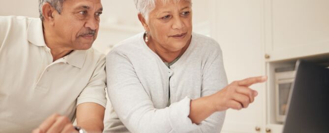 older adult couple looking at a laptop; behavioral economics senior living decision