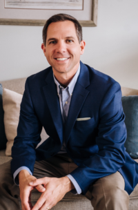Brad Breeding color photo sitting down leaning over with hands on knees