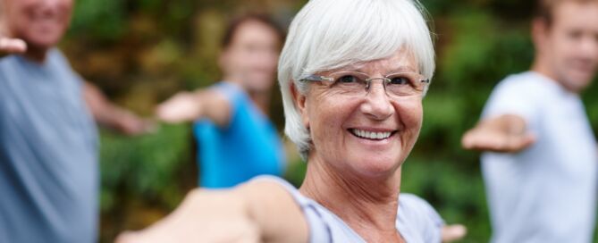 older woman doing yoga; wellness-first retirement communities